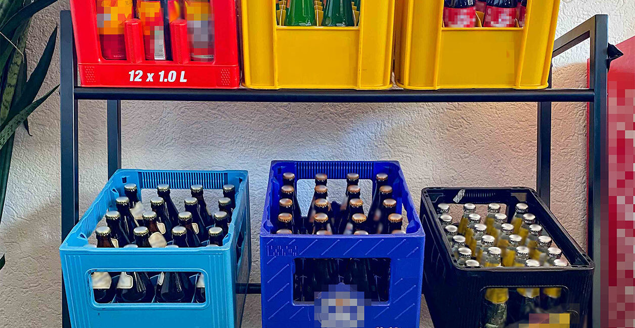 Getränkekistenregal in schwarz von Athelon mit sechs Kisten darauf.