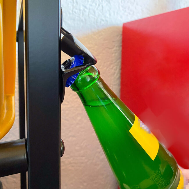 Flaschenöffner des Getränkekistenregals beim Öffnen einer grünen Glasflasche.