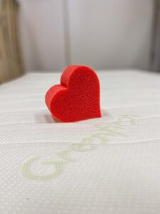 Greenfirst Schriftzug auf Matratzenbezug mit Schaumstoffherz.