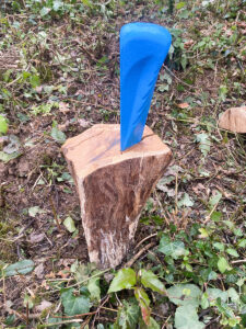 Spaltkeil im Holz steckend