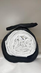 Kamelhaarbettdecke eingerollt in der geöffneten Tragetasche.